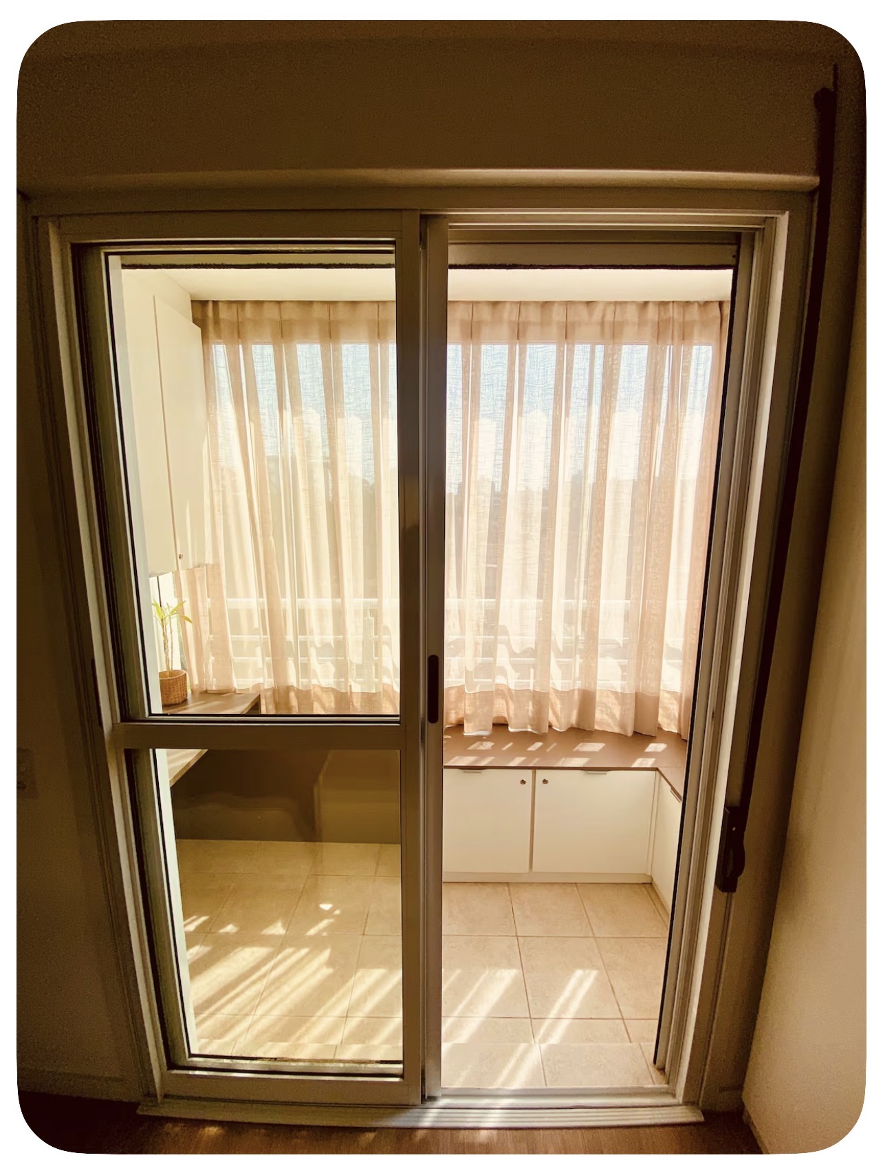 Sacada envidraçada com cortinas e bancada